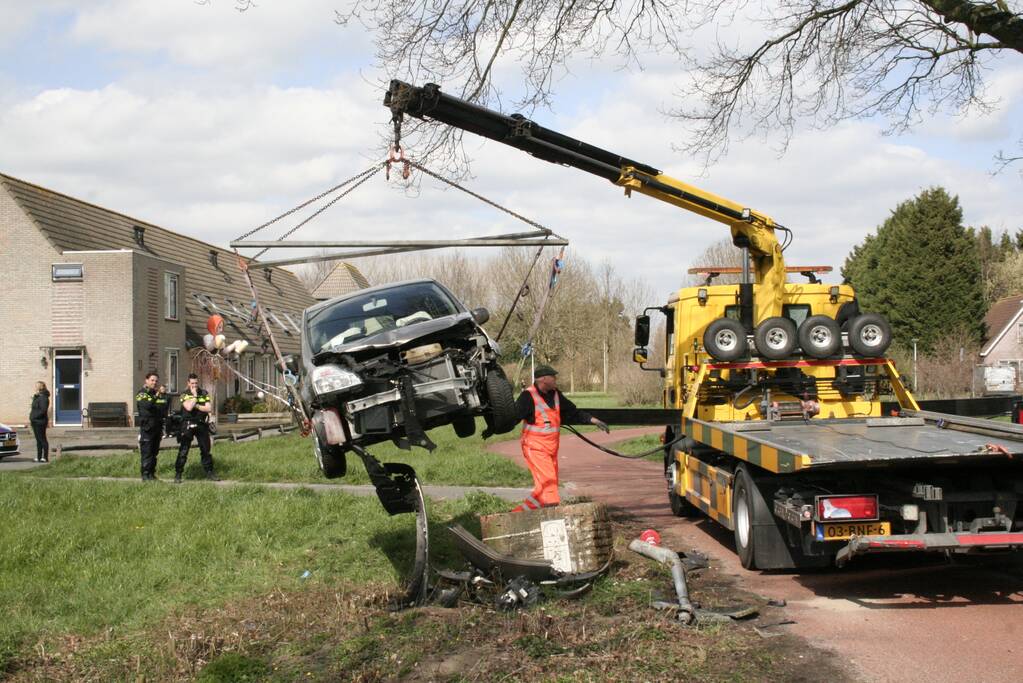 Auto botst op betonblok met lantaarnpaal