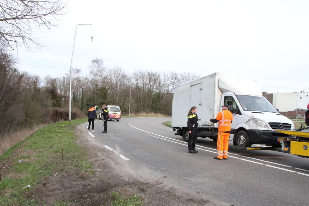 Bakwagen valt op zijkant in bocht