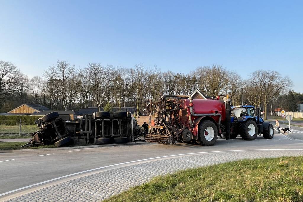 Giertank met mest gekanteld op rotonde