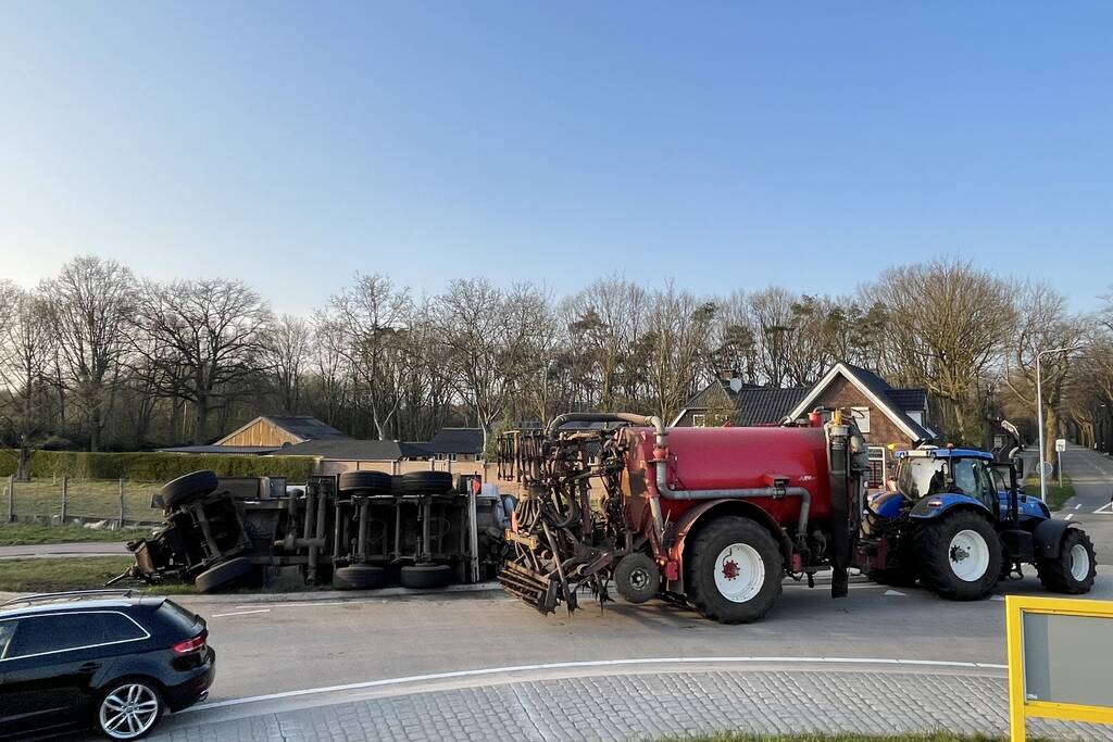 Giertank met mest gekanteld op rotonde