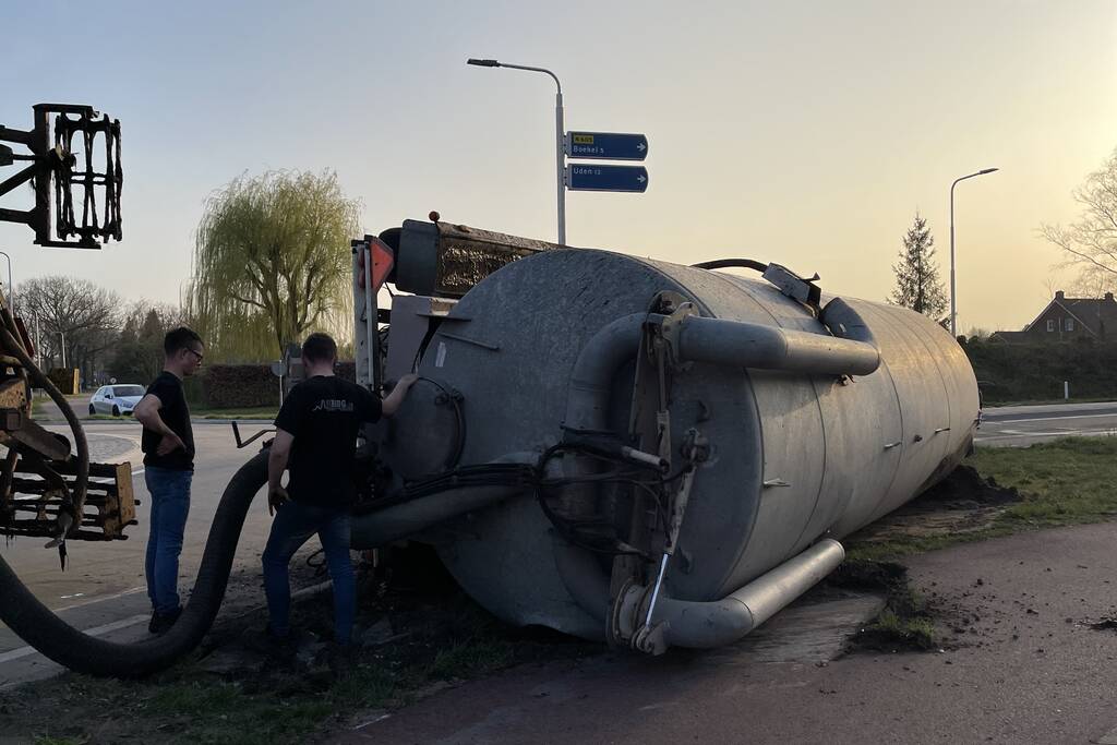 Giertank met mest gekanteld op rotonde