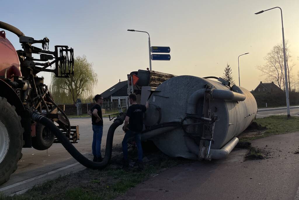 Giertank met mest gekanteld op rotonde