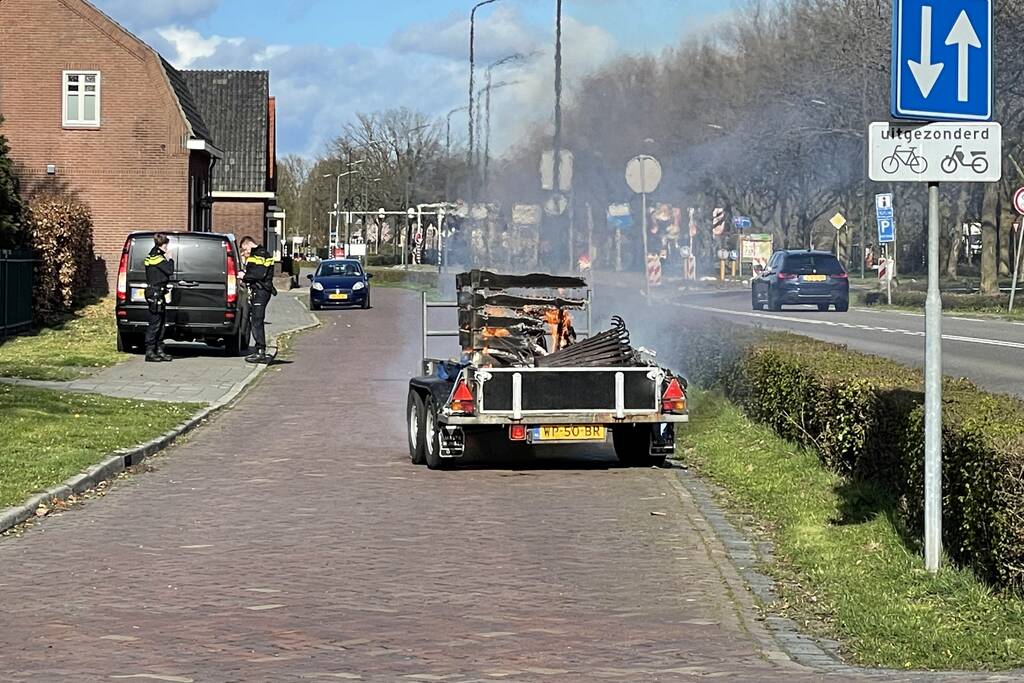 Brandweer blust brandende aanhanger