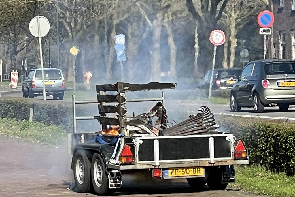 Brandweer blust brandende aanhanger