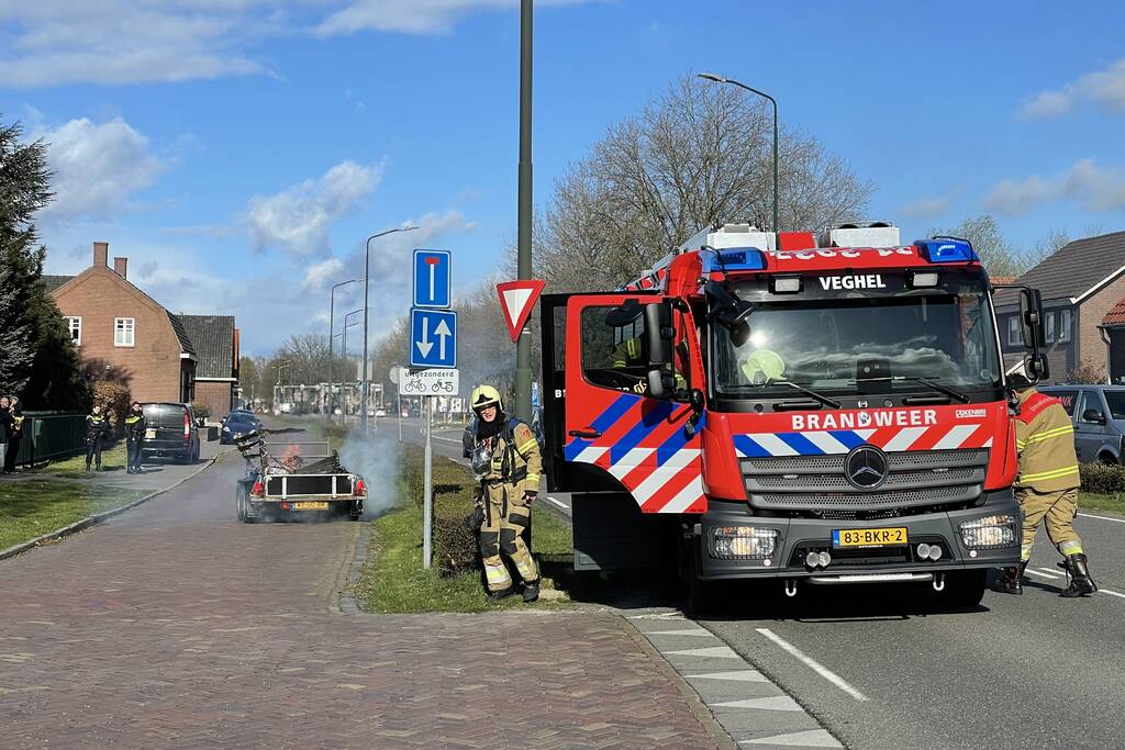 Brandweer blust brandende aanhanger