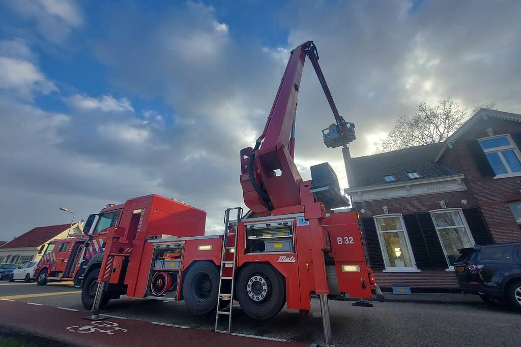 Brandweer veegt schoorsteen na brand
