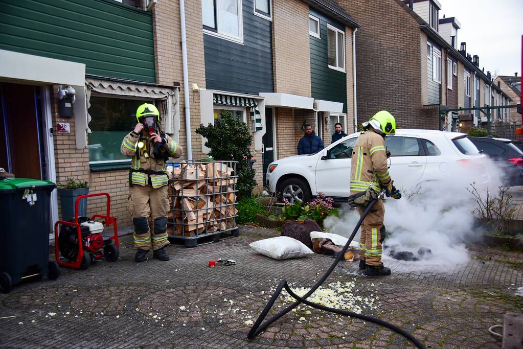 Brandweer blust stukken hout door brand in schoorsteen