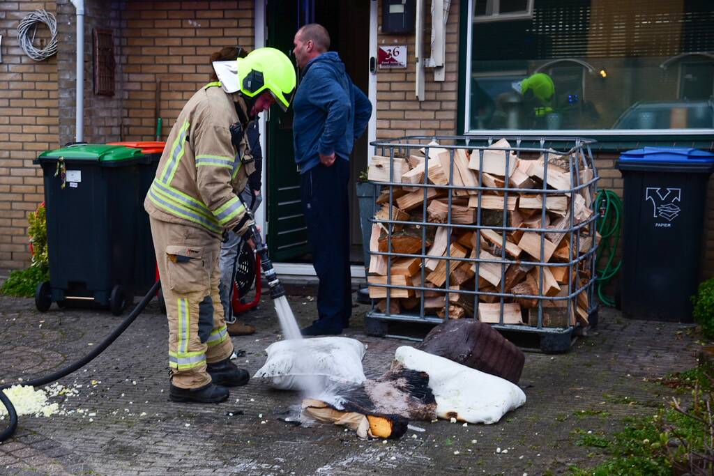 Brandweer blust stukken hout door brand in schoorsteen