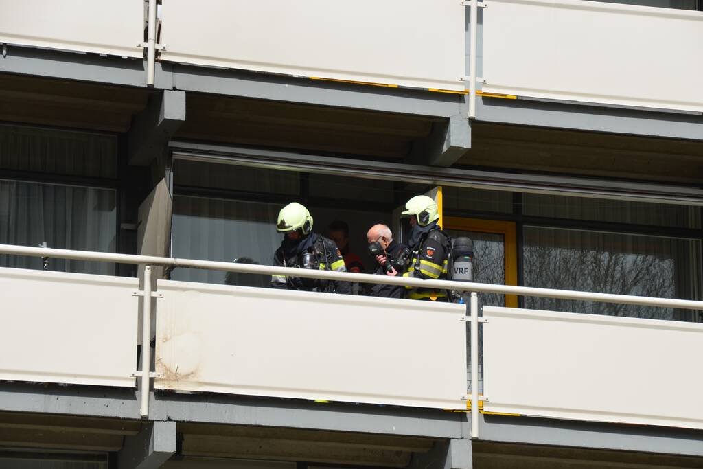 Brandweer blust brandende wasmand