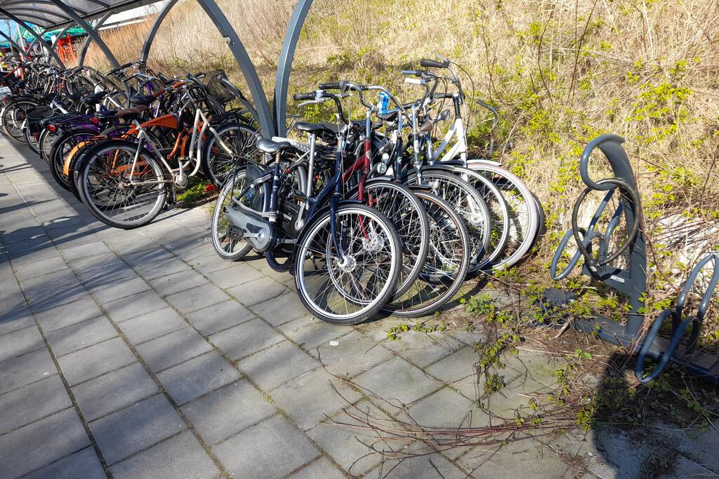 Fietser botst tegen geparkeerde fietsen
