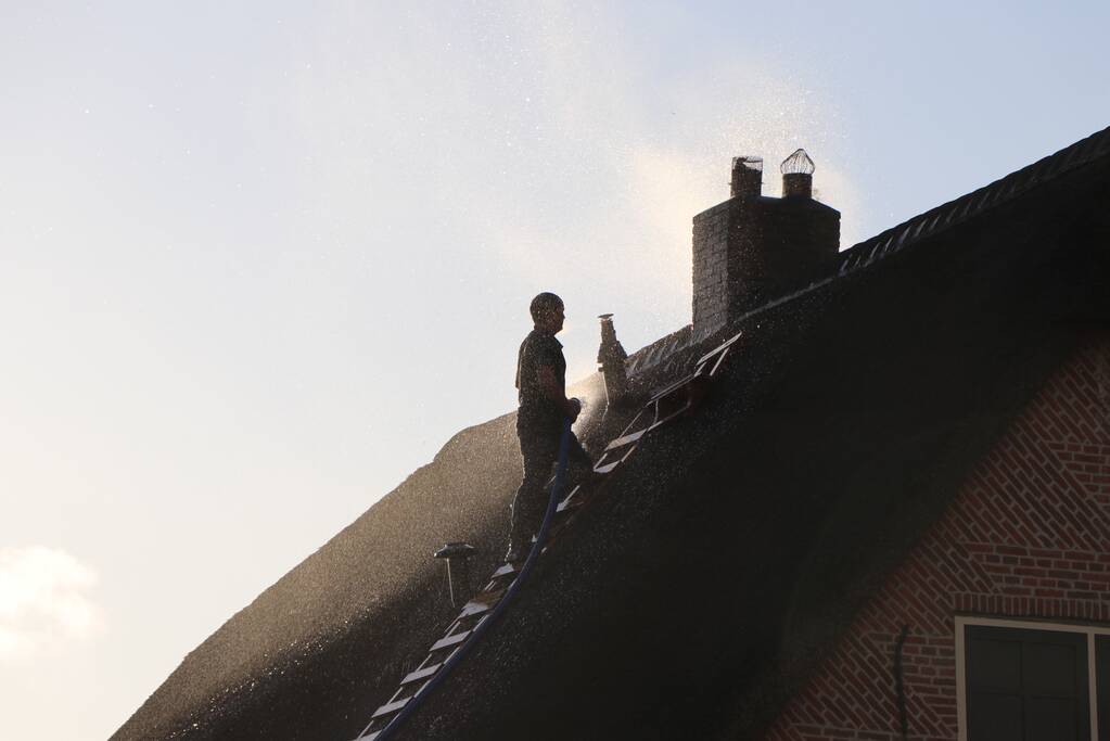 Schoorsteenbrand bij woning met rietendak