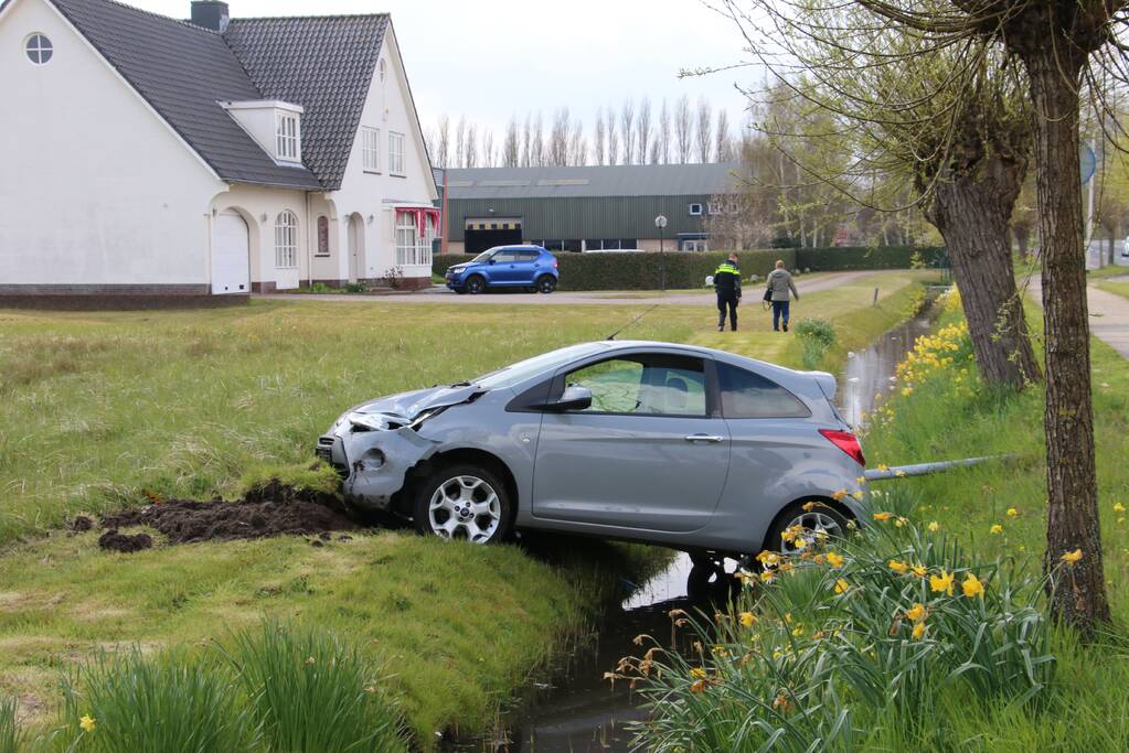 Auto schiet rechtdoor over rotonde en belandt bovenop sloot