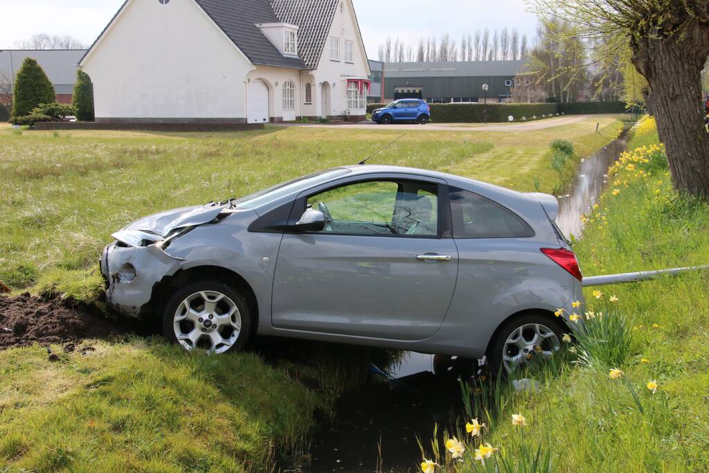 Auto schiet rechtdoor over rotonde en belandt bovenop sloot