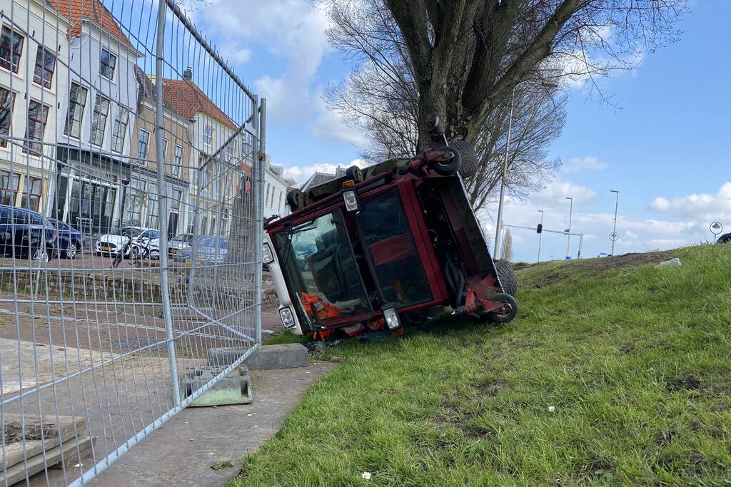 Grasmaaier valt van dijk af