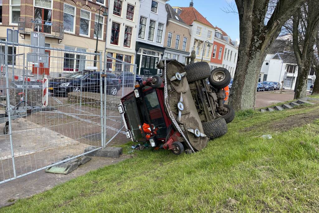 Grasmaaier valt van dijk af