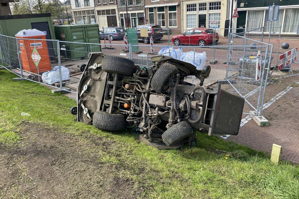 Grasmaaier valt van dijk af