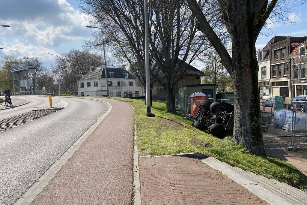 Grasmaaier valt van dijk af