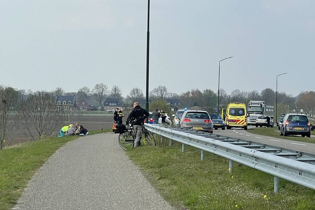Auto glijdt van dijk af na botsing en vliegt in brand