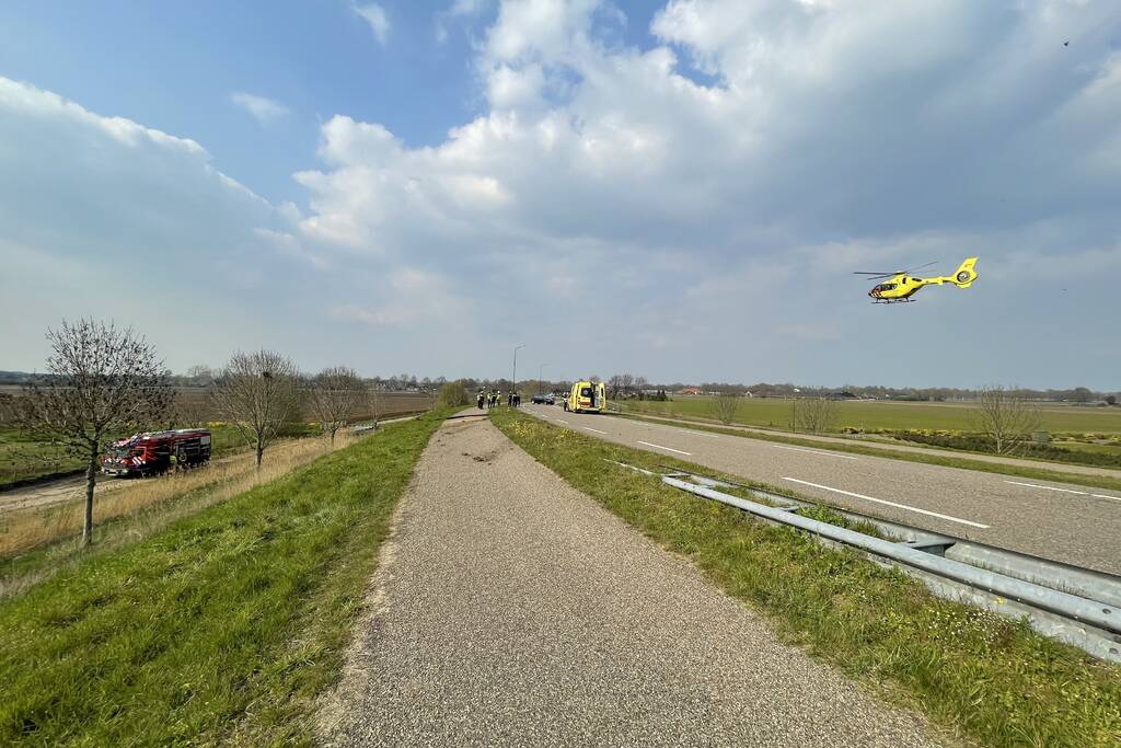 Auto glijdt van dijk af na botsing en vliegt in brand