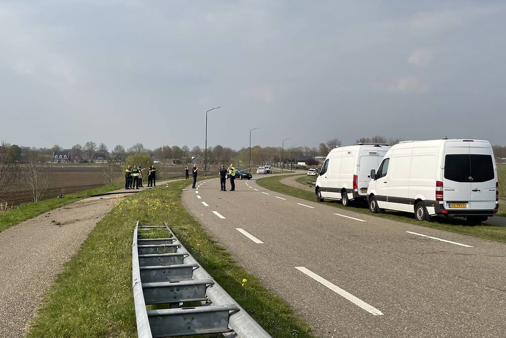 Auto glijdt van dijk af na botsing en vliegt in brand