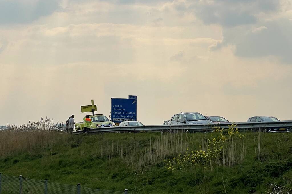 Auto glijdt van dijk af na botsing en vliegt in brand