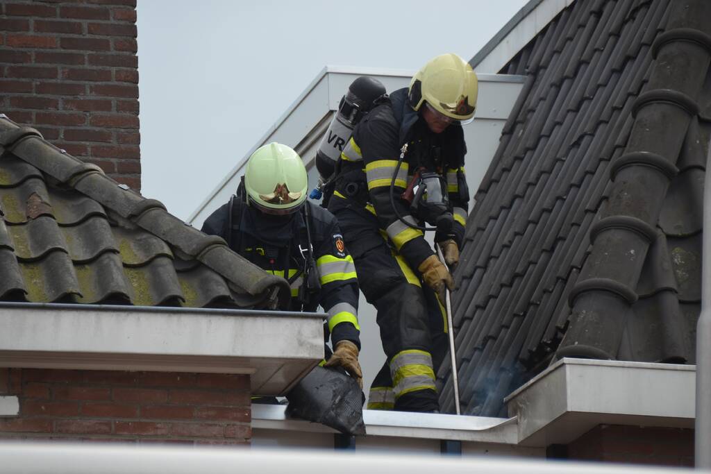 Brandweer blust brand op dak
