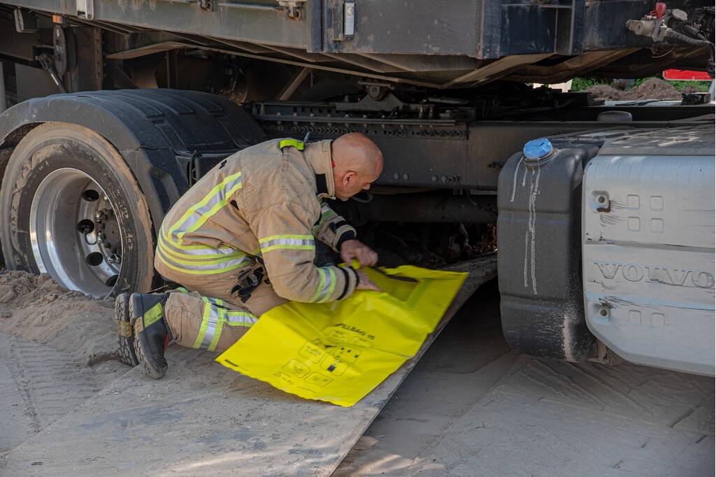 Vrachtwagen vast in het zand en verliest brandstof door lek