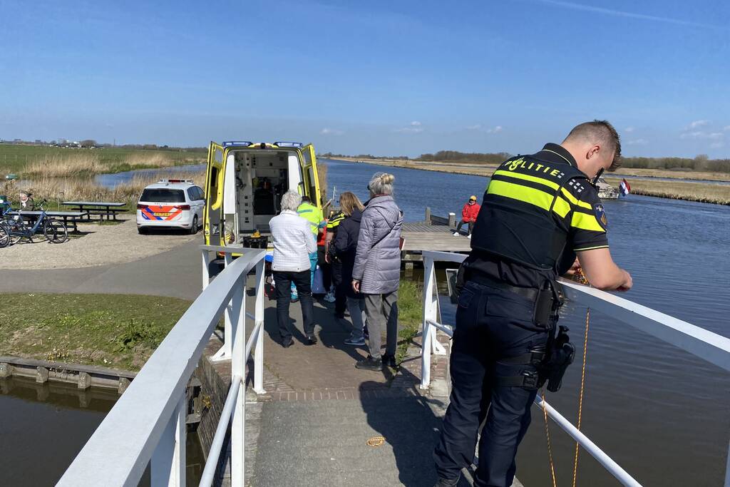 Vrouw kukelt met fiets van brug
