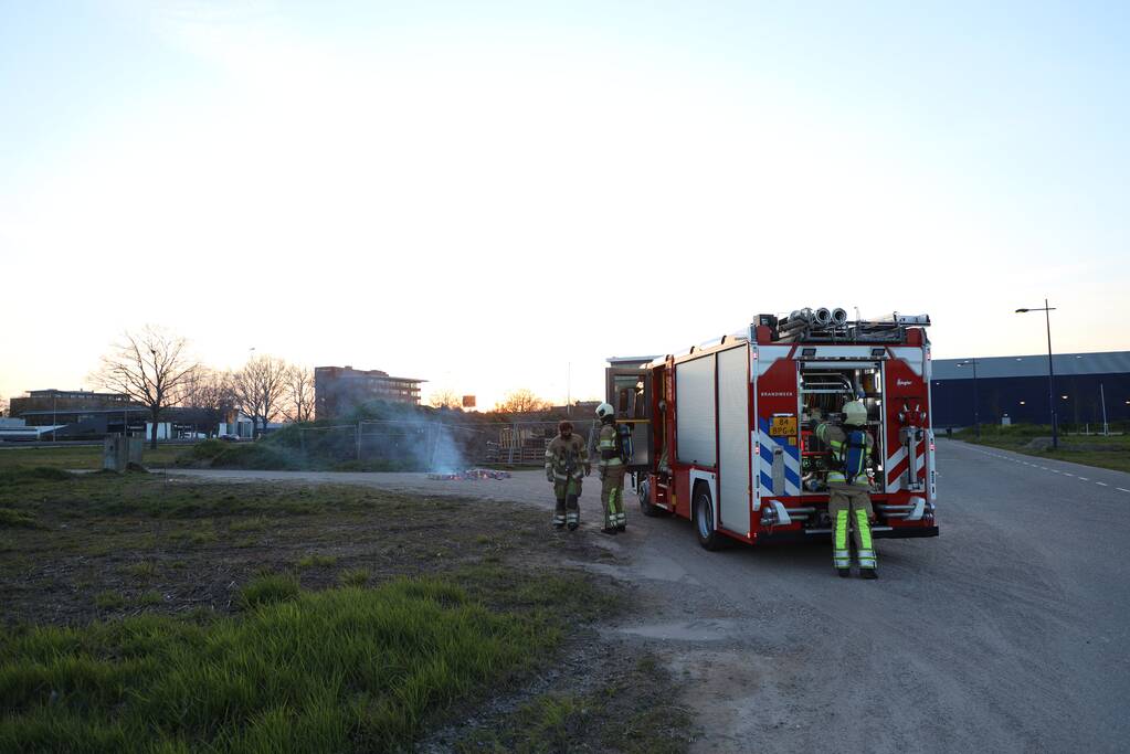 Brandweer blust brandende pallets
