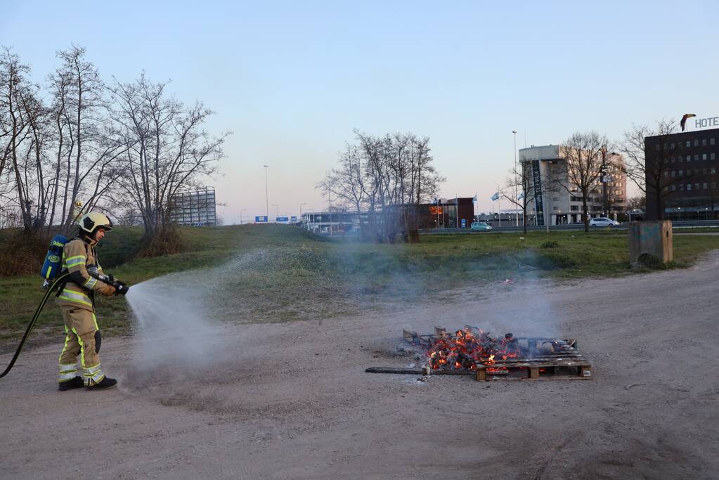 Brandweer blust brandende pallets