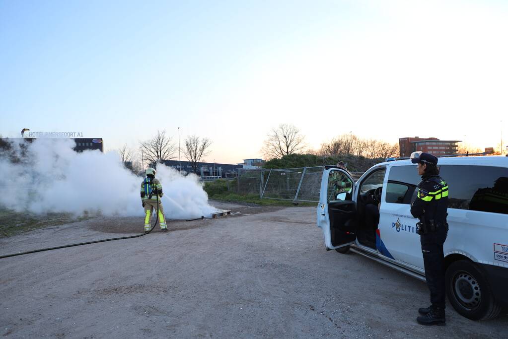 Brandweer blust brandende pallets