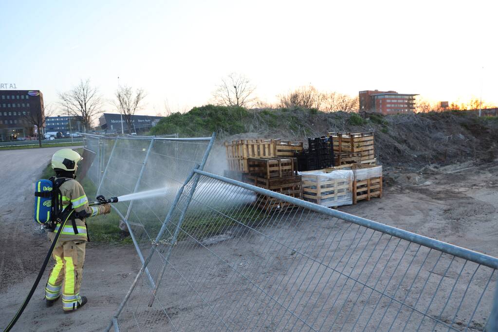 Brandweer blust brandende pallets