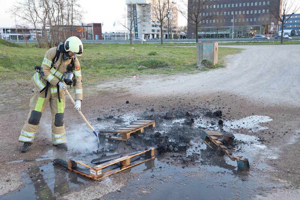 Brandweer blust brandende pallets
