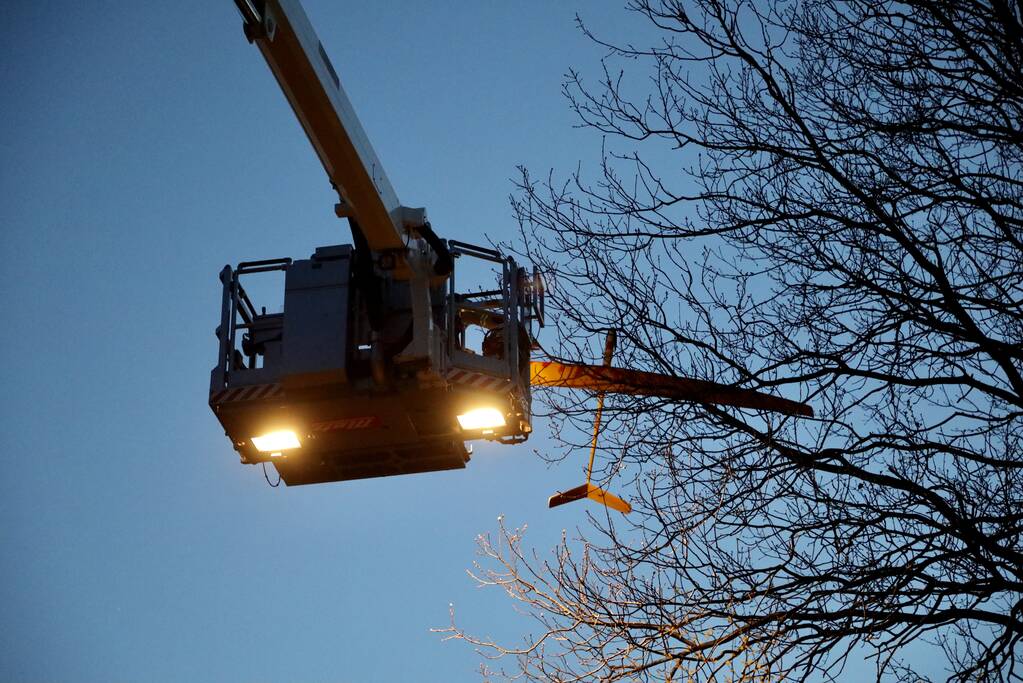 Brandweer haalt vastzittend modelvliegtuig uit boom