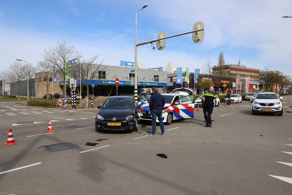 Politieauto met spoed ramt personenauto