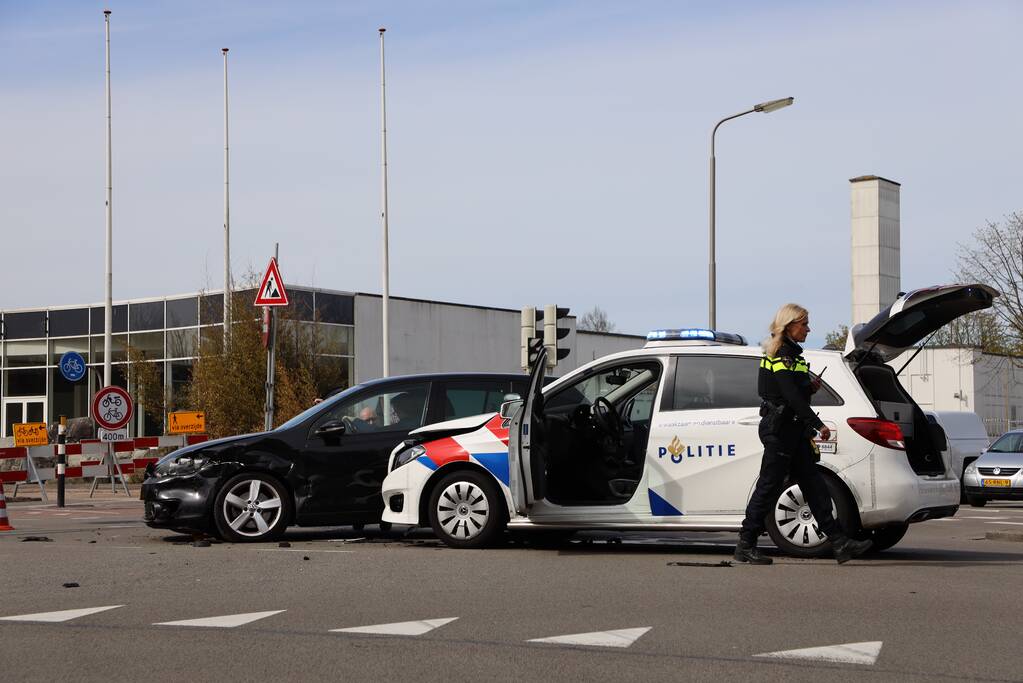 Politieauto met spoed ramt personenauto