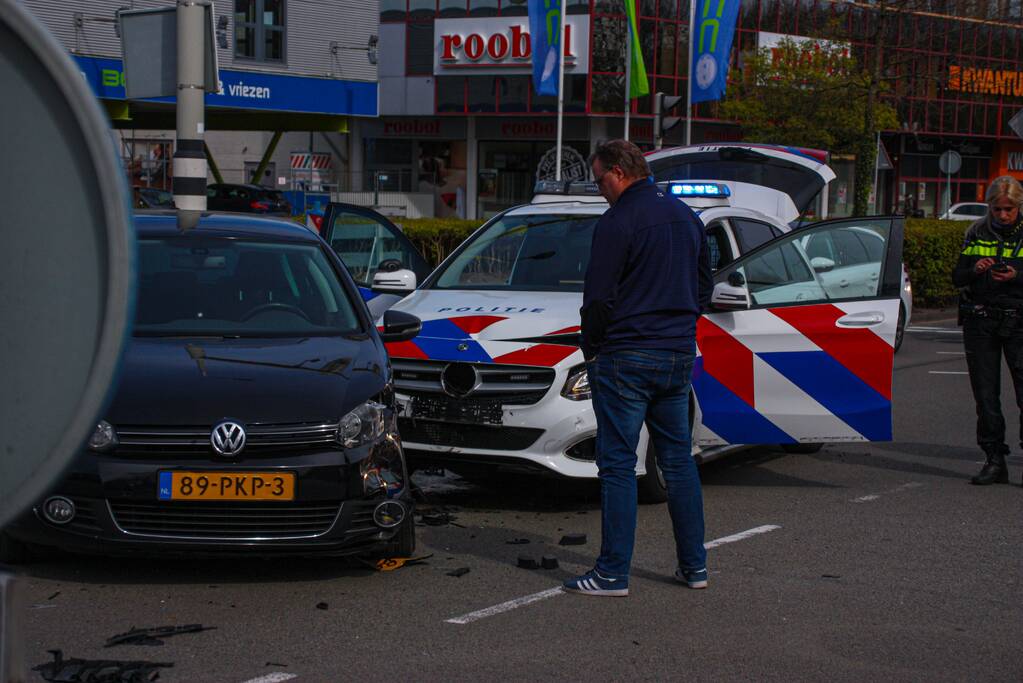 Politieauto met spoed ramt personenauto