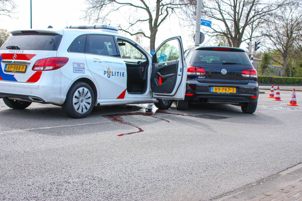 Politieauto met spoed ramt personenauto