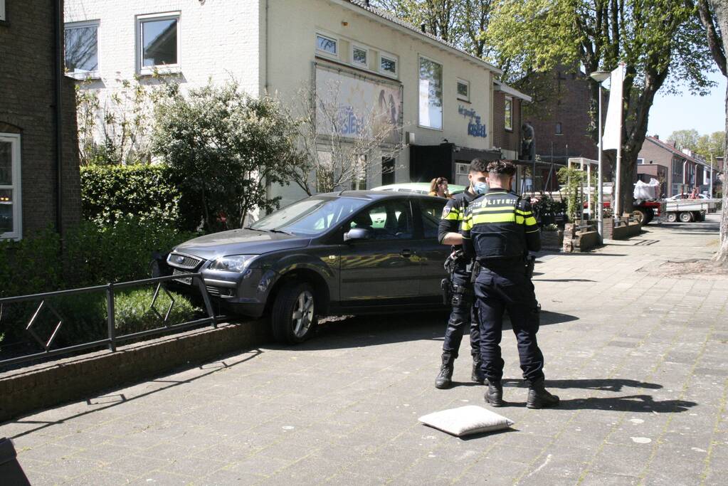 Bestuurder rijdt met auto op tuinhek