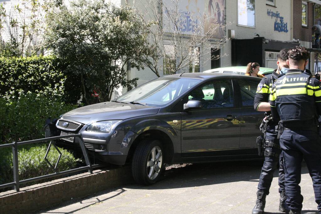 Bestuurder rijdt met auto op tuinhek