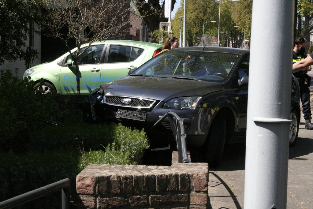Bestuurder rijdt met auto op tuinhek