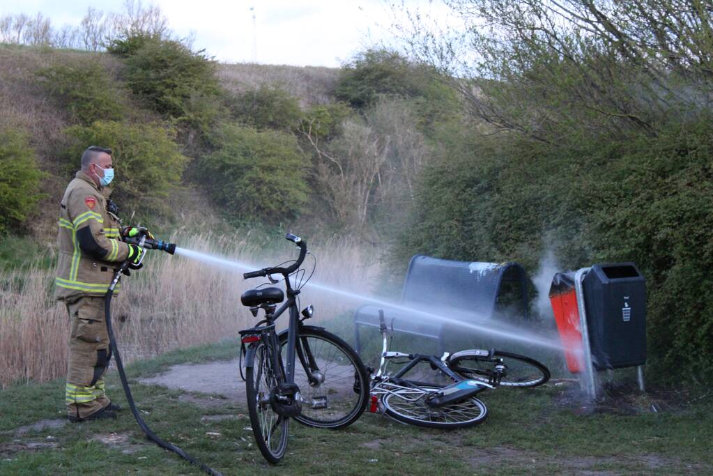 Brandweer blust brand in prullenbak