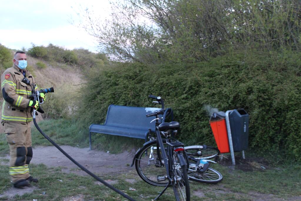 Brandweer blust brand in prullenbak