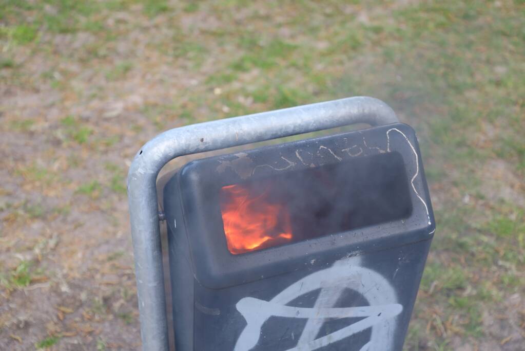 Brandweer blust brand in afvalcontainer