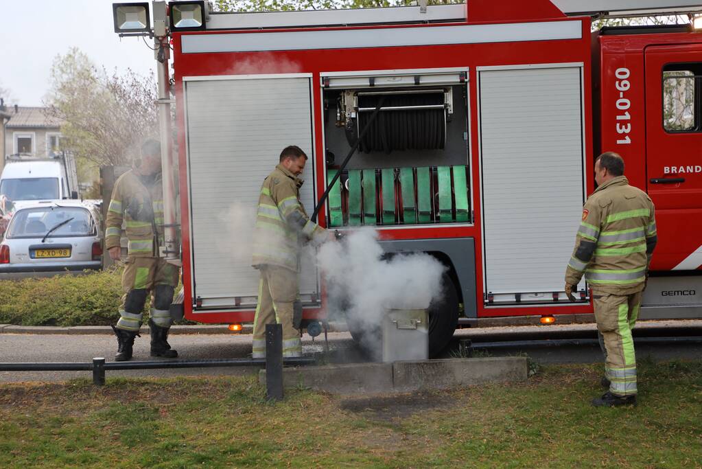 Brandweer blust brand in afvalcontainer