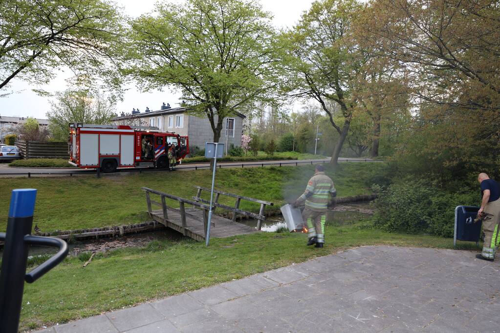 Brandweer blust brand in afvalcontainer