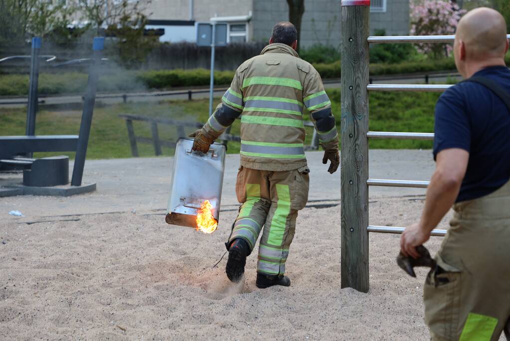 Brandweer blust brand in afvalcontainer