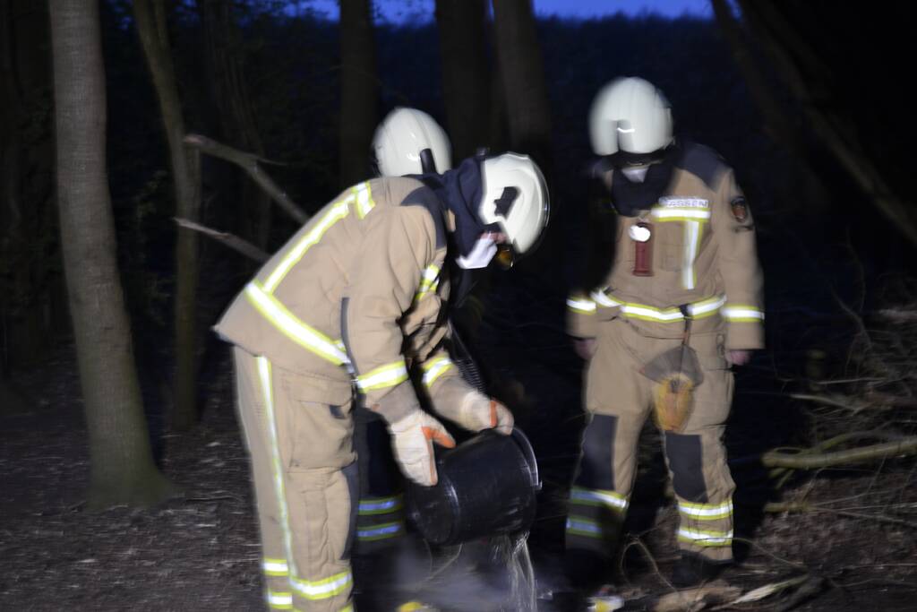 Brandweer blust kampvuur met emmers water