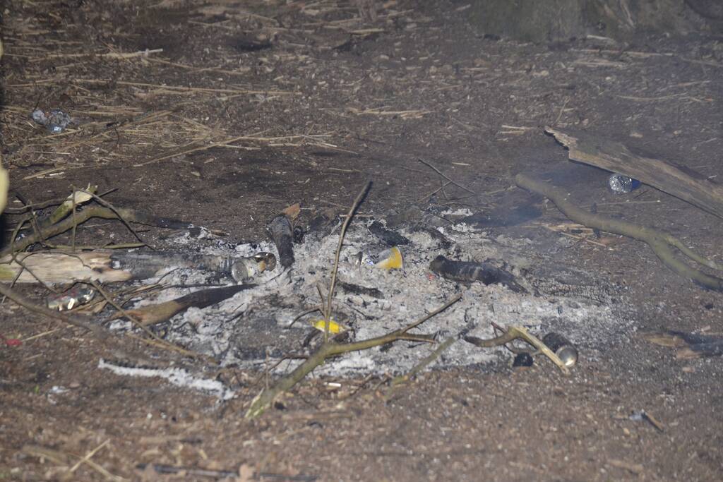 Brandweer blust kampvuur met emmers water