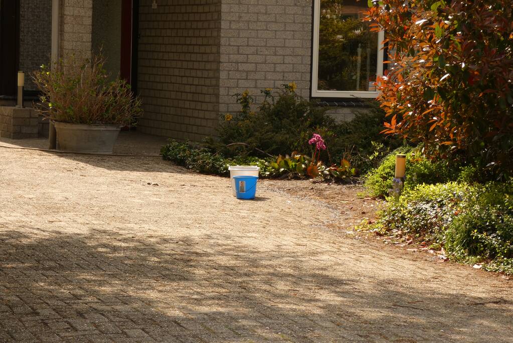 Bewoners blussen coniferenbrand met emmers en tuinslang